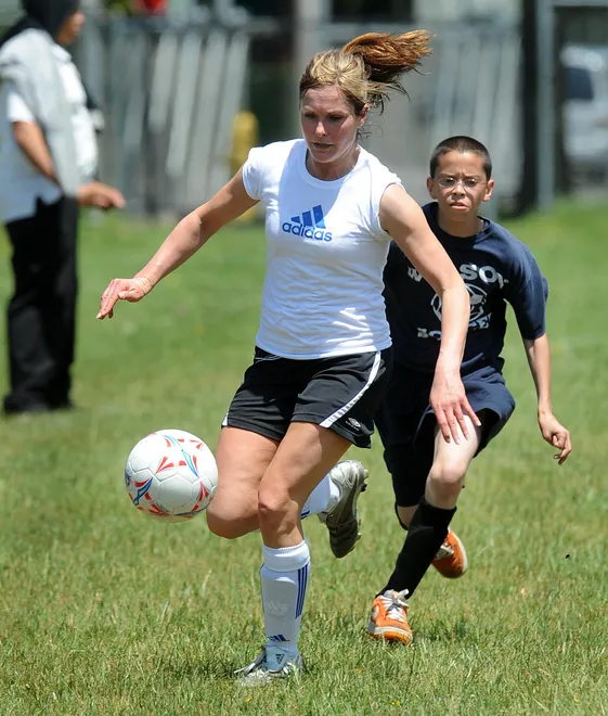 Wilson Middle School seventh-grade reading teacher Julie Kuhar, left, moves the ball past seventh-grader Luis Rodriguez during a traditional end-of-year soccer match at the Erie school on May 29, 2009. Two mixed teams of male and female students and teachers played for fun and bragging rights in front of the student body and faculty.