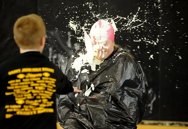 St. John-Holy Rosary Eastside Catholic School fifth-grade teacher Kerry O'Connor takes a whipped-cream pie in the face from student Conor Donoghue at the Erie school on Feb. 2, 2010. As a fundraiser for charity, students donated money for chances to throw a pie at their teacher during a pep rally celebrating Catholic Schools Week. The students raised $75 for the Maleno Family to Family Fund.