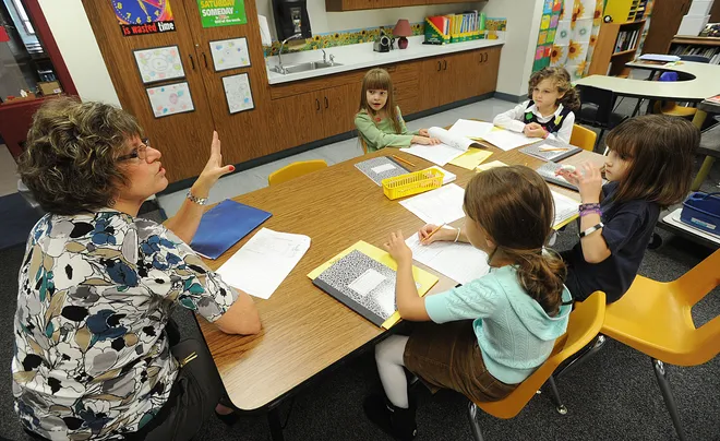 Teacher Kim Edinger works with Robison Elementary School second-graders Calleigh Nurse, 7, left, Kendra Honey, 7, top, Hannah Wilkerson, 7, right, and Nadia Popov, 7, bottom, during a class assignment in a Gifted Enrichment Model for Students classroom on Oct. 1, 2010.