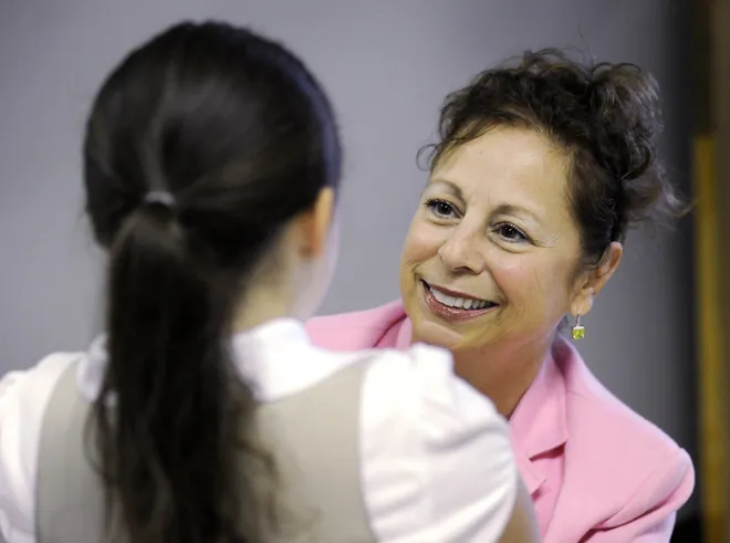Wayne School kindergarten teacher Patricia Territo welcomes student Susan Vera to her class on the first day of school for the Erie School District on Aug. 30, 2010.