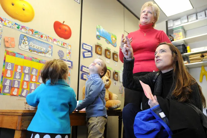 Parent Stephanie Fritts, far right, asks a question of St. George School preschool teacher Chris Theiss during an open house at the school on Jan. 30, 2011. At left are Stephanie Fritts' children, Sophie Fritts, 18 months, left, and Jack Fritts, 3.
