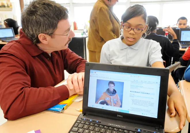 Jim Connell, a learning support teacher at Emerson-Gridley School, in Erie, left, works with Jada Tate, a fifth-grade student, on her Black History Month project at the school Feb. 11, 2011. On the computer screen is Mae Jemison, the first Black woman astronaut to go into space.