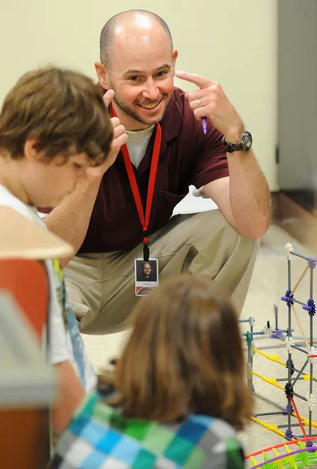 From left, James W. Parker Middle School teacher Chris Triola talks with sixth-graders Jordan Peterson, left, and Emma Campbell, both 12, as they work to finish a roller coaster built out of Knex on June 1, 2011. Triola said the kids learn valuable math and science skills while having fun building an entire amusement park with classmates. Most desktops held rides for parents to see during an open house.
