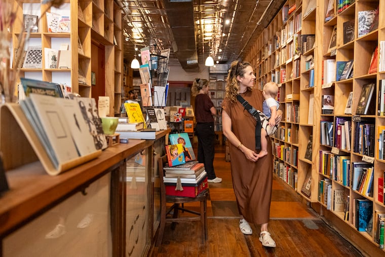 Lindsey Scannapiecco, who lives in Queen Village, and her son browse the shelves inside Brickbat Books.