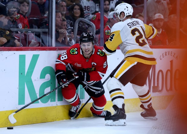 Chicago Blackhawks center Connor Bedard (98) and Pittsburgh Penguins defenseman Spencer Stastney (24) battle along the boards in the first period of a game at the United Center in Chicago on Oct. 13, 2026. (Chris Sweda/Chicago Tribune)