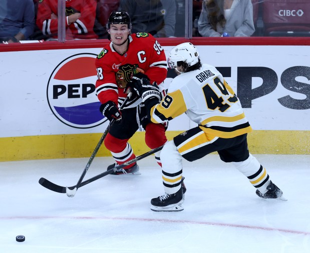 Chicago Blackhawks center Connor Bedard (98) passes the puck by Pittsburgh Penguins defenseman Samuel Girard (49) in the second period of a game at the United Center in Chicago on Oct. 13, 2026. (Chris Sweda/Chicago Tribune)
