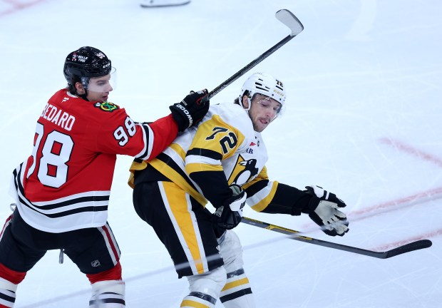 Chicago Blackhawks center Connor Bedard (98) and Pittsburgh Penguins defenseman Declan Carlile (72) battle in the second period of a game at the United Center in Chicago on Oct. 13, 2026. (Chris Sweda/Chicago Tribune)