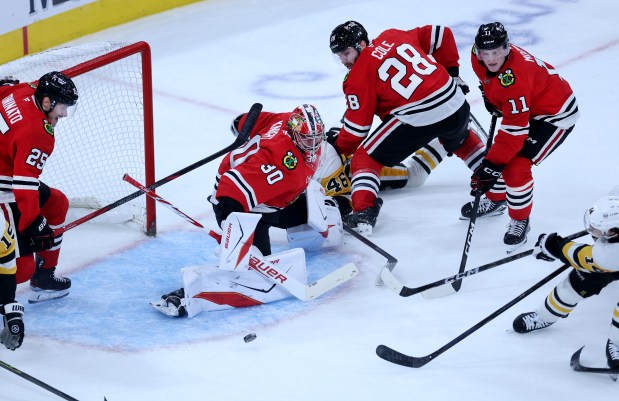 Chicago Blackhawks goaltender Spencer Knight (30) is unable to prevent Pittsburgh Penguins left wing Nick Robertson (far right) from scoring a goal in the second period of a game at the United Center in Chicago on Oct. 13, 2026. (Chris Sweda/Chicago Tribune)