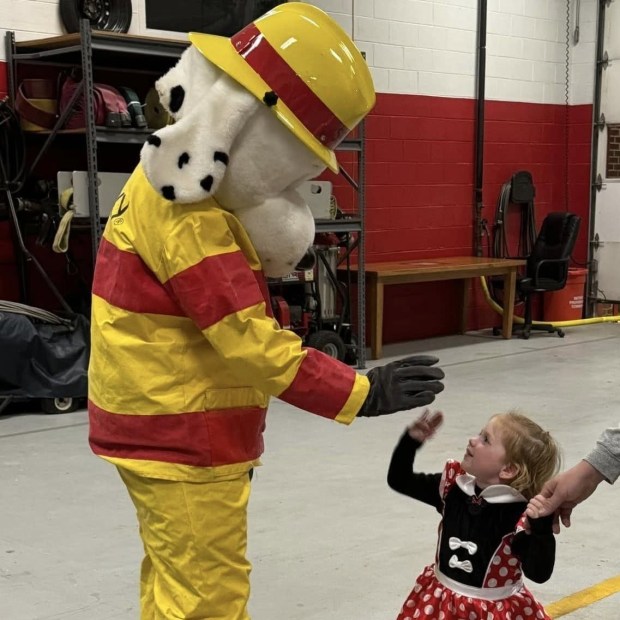 Sparky the Fire Safety Dog interacts with a young attendee at a previous Halloween-themed Garden City Fire Company open house event. (COURTESY OF GARDEN CITY FIRE COMPANY)