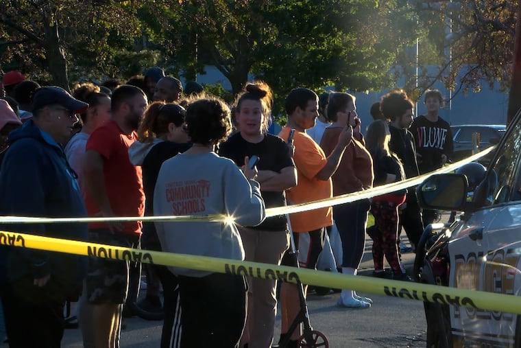 In this image from video provided by WJET, bystanders gather outside the scene of a shooting in Erie, Pa., on Friday evening, Oct. 9, 2026.
