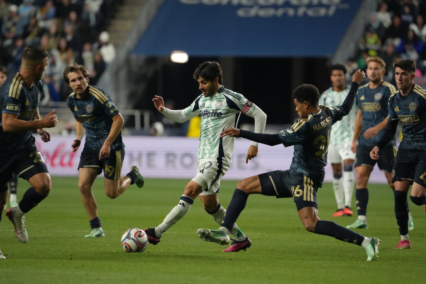 Midfielder Carles Gil dribbles past Philadelphia Union defender Nathan Harriel as the Revolution won 2-1 on Saturday, Oct. 24.
