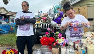 Julius Windham (left) visits a memorial outside the home where authorities say a gunman killed multiple people, including Windham's daughter, in Erie, Pa., on Sunday.