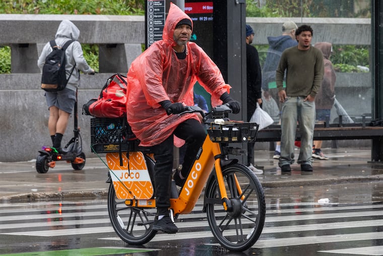 A delivery driver rides across John F. Kennedy Boulevard near Love Park during last weekend's nor'easter. Big changes may be in the winds.