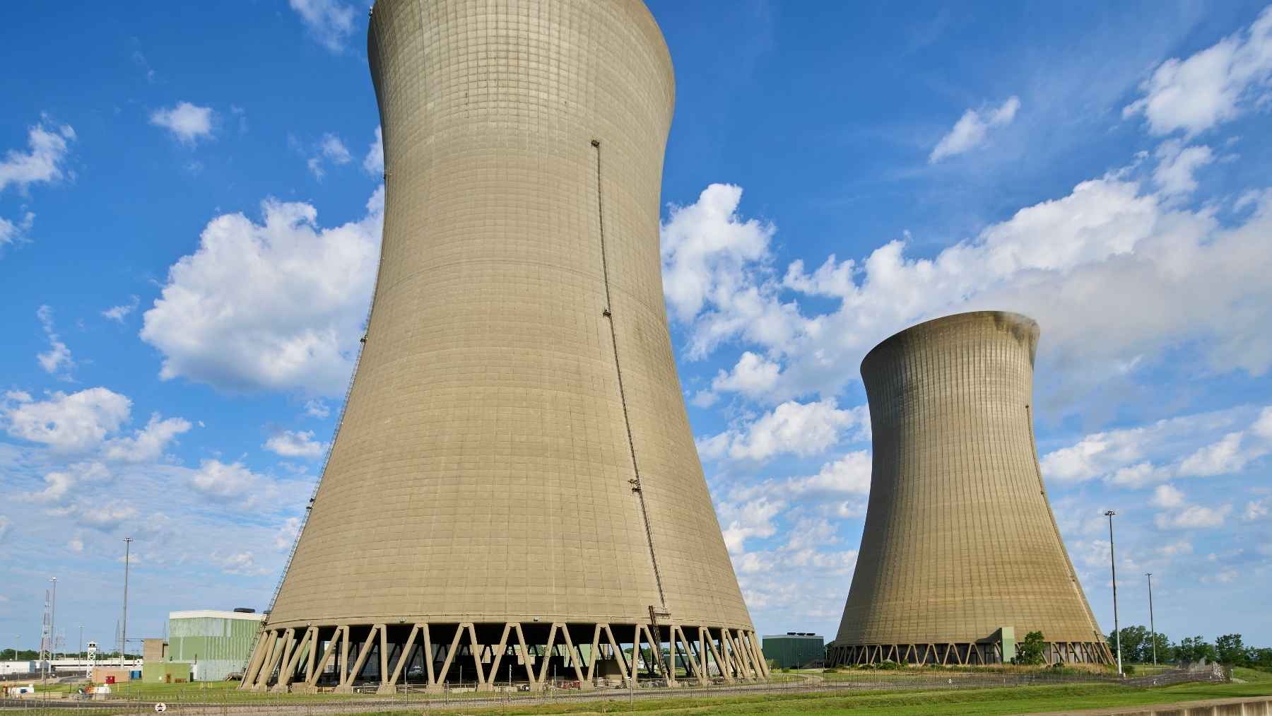 A 516-foot cooling tower stands unused beside its working twin at a Lake Erie nuclear plant, built for a second reactor that was canceled with the tower already finished, and the plant is now preparing to squeeze 213 more megawatts out of the one reactor it did get