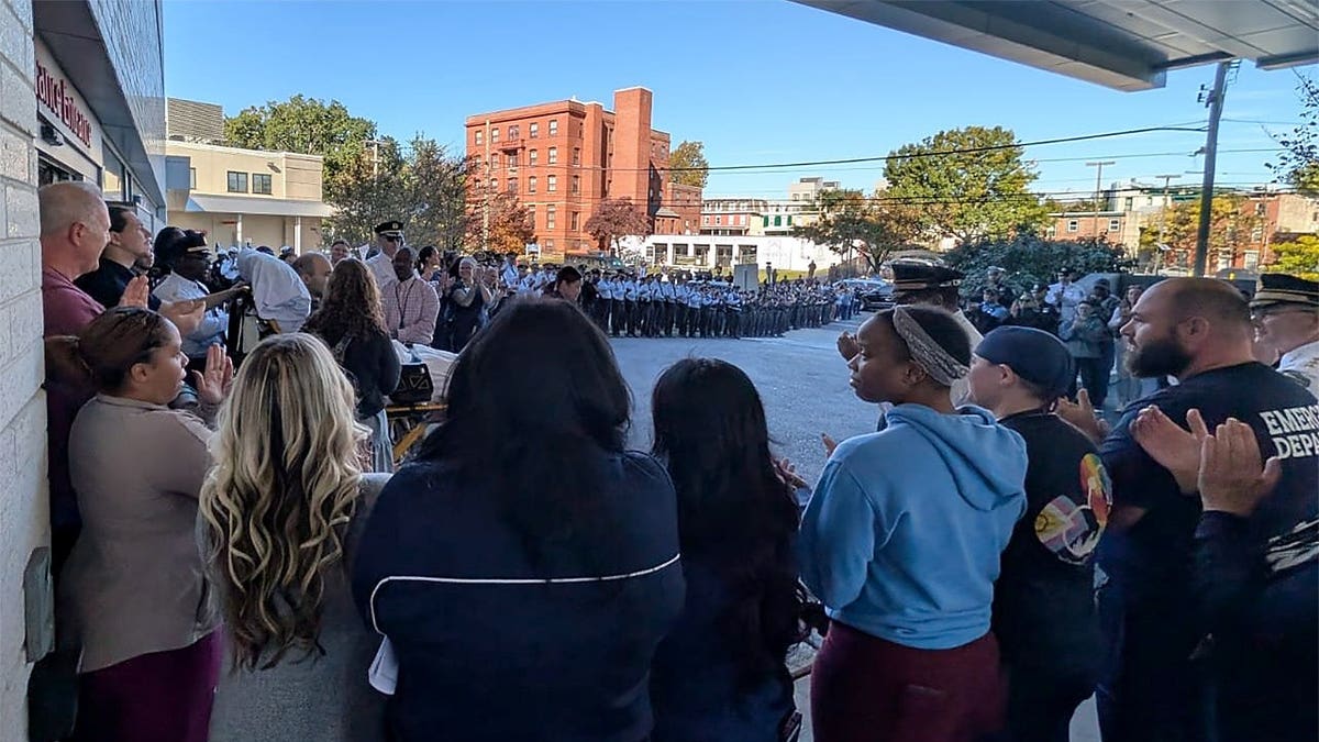 A large crowd of police officers and other supporters lines the entrance outside Penn Presbyterian Medical Center.