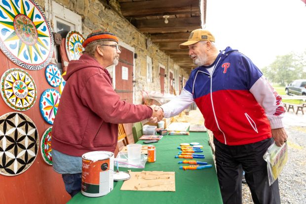 Berks Commissioner Christian Leinbach, right, greets Eric Claypoole, who demonstrated his traditional barn art during Heemet Fesch at the historic Sharadin Farmstead in Kutztown on Sept. 26. (Photo courtesy of Kutztown University Relations)
