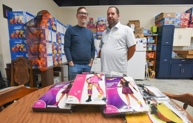 Andy Granick, regional organizer for Affordable Pennsylvania, and John Rosengrant, executive director for the NEPA Youth Shelter, pose for a photograph in front of the some of the donated costumes at the NEPA Youth Shelter in Scranton Thursday, October 15, 2026. (SEAN MCKEAG / STAFF PHOTOGRAPHER)