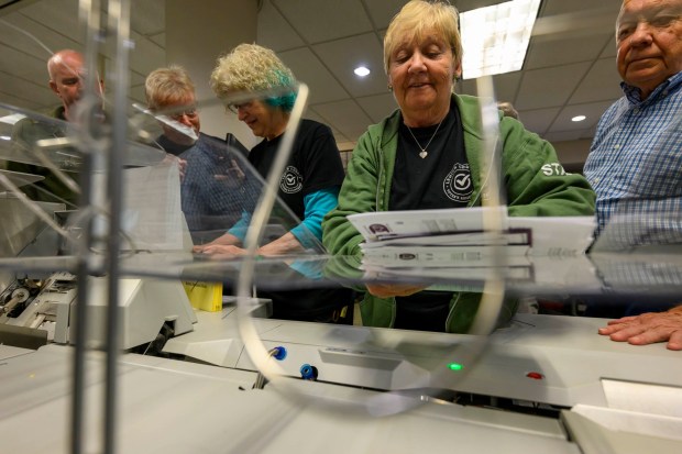 Lehigh County employees Janet Reilly and Andrea Lerner demonstrate how ballots are opened and sorted as Irv Kister of Lower Macungie Township and others watch Thursday, Oct. 8, 2026, during the county voter registration office's first open house, at the government center in Allentown. The open house gave the public a look at where mail-in ballots are opened, processed and counted and the tabulation equipment used during elections, and learn more about how the equipment operates and how the election process comes together. (April Gamiz/The Morning Call)