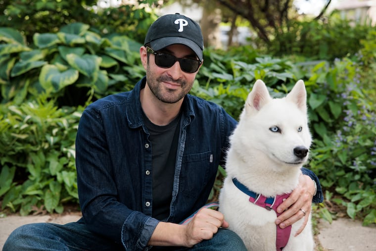 Elias Weiss Friedman, photographer and founder of the Dogist, posed for a portrait with his dog Elsa in his childhood neighborhood on May 20, 2025, in Narberth. On Sunday Oct. 4, Friedman will lead a group dog walk along the Schuylkill Banks in Philadelphia.