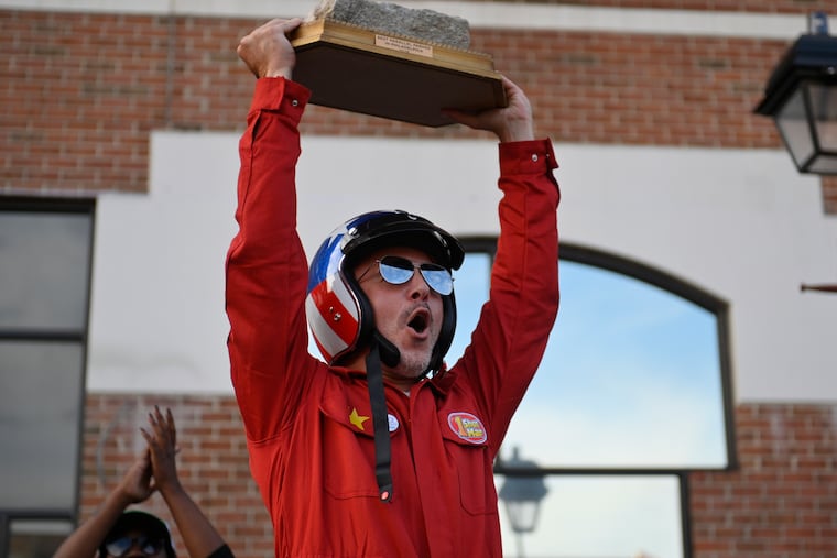 Mario "One-Shot Mar" Zucca hoists the trophy he received Saturday for winning the first Philadelphia Parallel Parking Championship at Headhouse Plaza.
