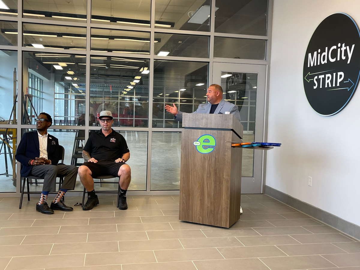 Jeremy Peterson, CEO of the Erie Metropolitan Transit Authority, welcomes Michael Miodis (center) and Odis 12 to the Mid City Strip at 127 E. 14th St. Miodis sits next to EMTA board chairman Ben Wilson.