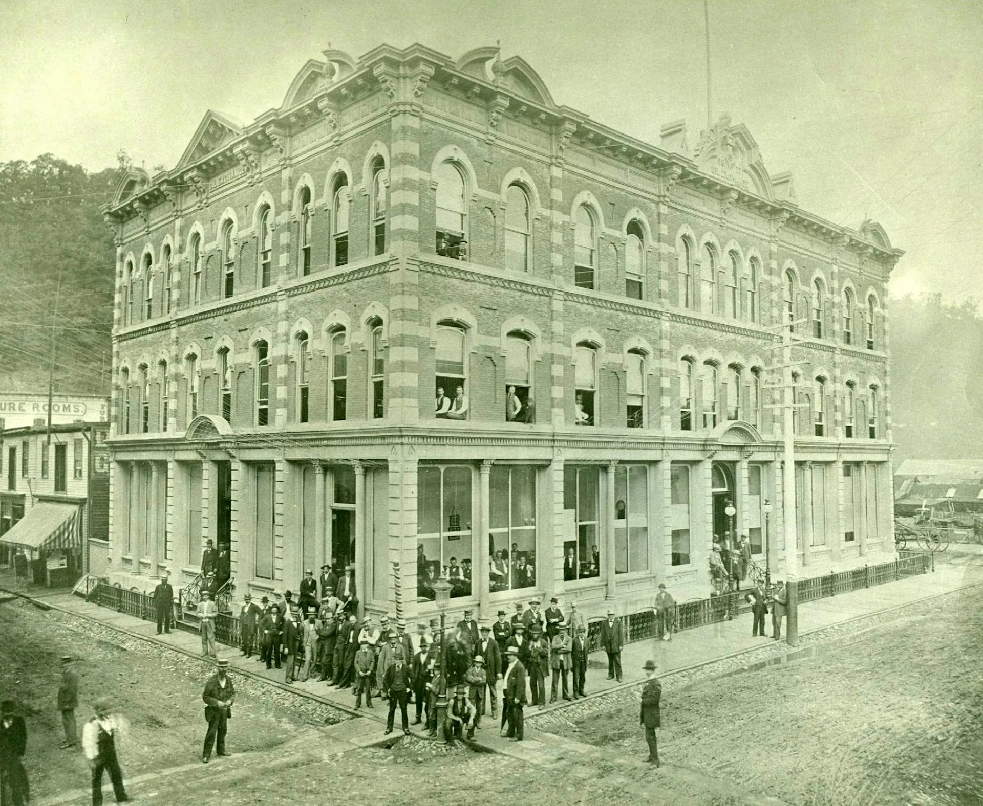Businessmen are seen outside an ornate building in a black-and-white photo.