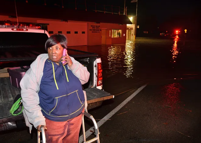 Norma Young, 61, of Erie, makes a call to get a ride home after she and about 100 other people were rescued from the social hall at the Belle Valley Fire Department following severe flooding on Nov. 5, 2017. Young and the others were playing bingo when they were evacuated because of the flooding. [CHRISTOPHER MILLETTE/ERIE TIMES-NEWS]