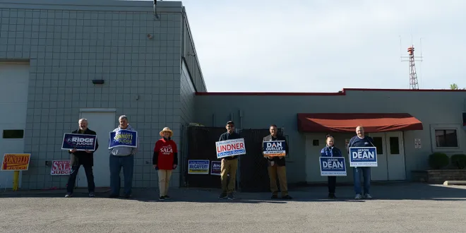 Voters are greeted by campaigners outside the Belle Valley Fire Department social hall on May 21, 2019, during the municipal primary. [JACK HANRAHAN/ERIE TIMES-NEWS]