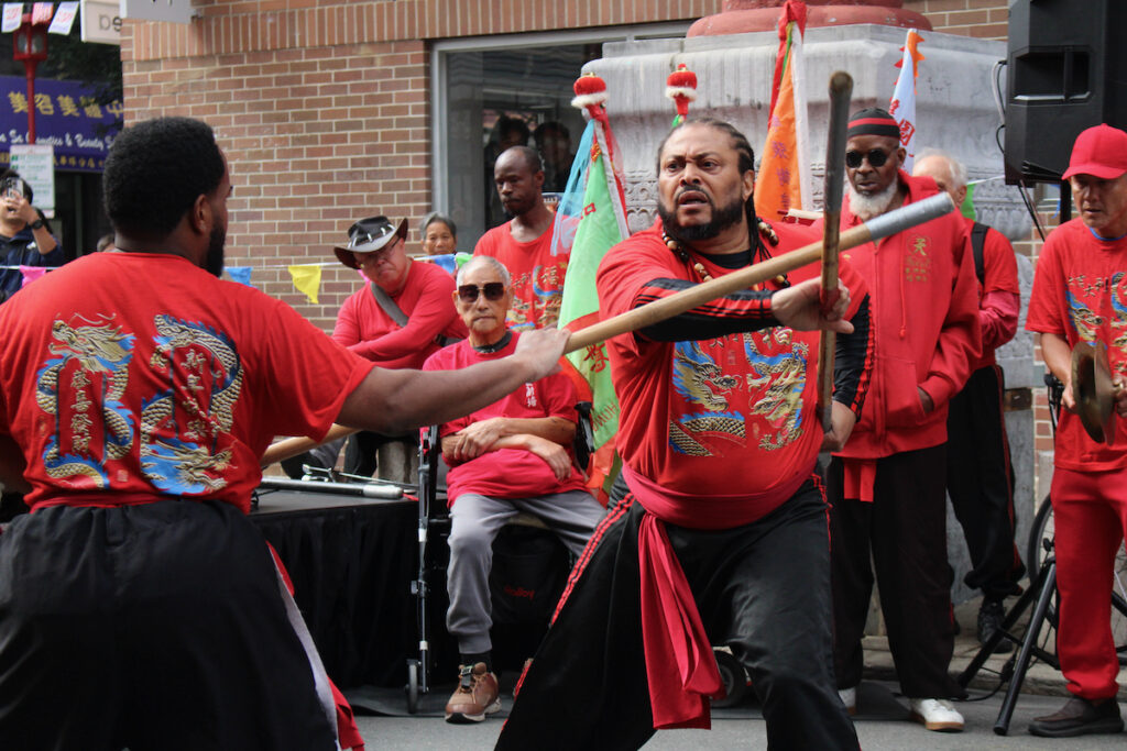 Members of Cheung’s Hung Gar Kung Fu martial arts school perform wielding dueling sticks