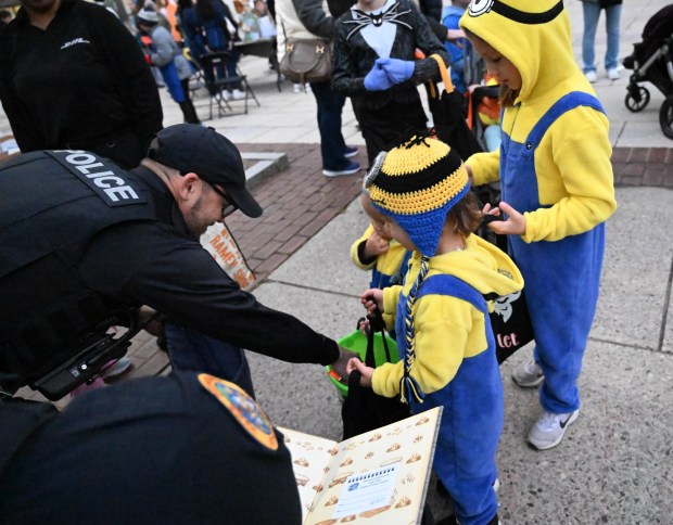 Scarlet,7, Emmett,4, and Miles,2, dressed as Minions receive candy as they participate in a Trunk or Treat on Monday, Oct. 20, 2025, at Bethlehem City Hall. The event, hosted by the city health bureau, included a disc jockey, costume contest, and children's activities and games. (Amy Shortell/The Morning Call)
