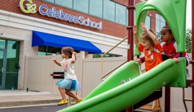 Children playing on a green slide in front of a building featuring Celebree School signage.