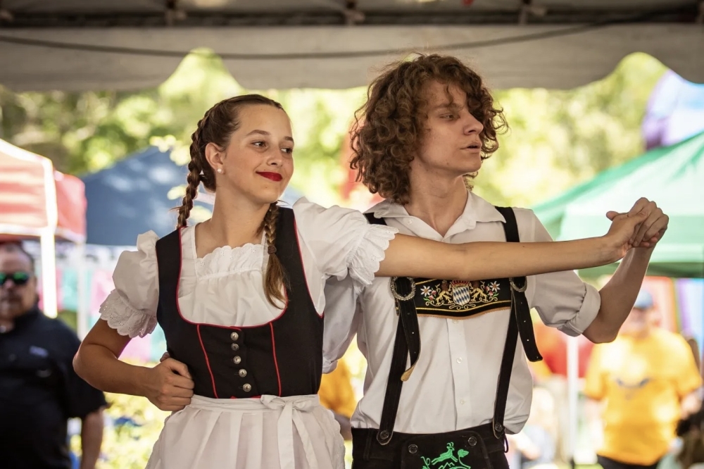 man and a woman dressed in traditional German clothing dancing