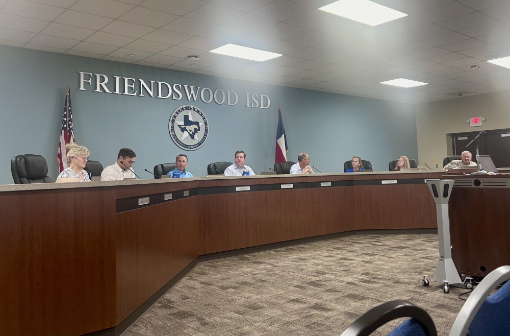 people sit behind a dais desk