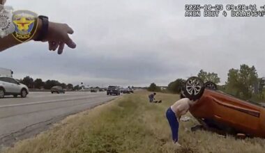 This image taken from video released by the Fort Worth Police Department shows officers responding to an overturned car before pulling a baby out from underneath Thursday, Oct. 23, 2025, in Fort Worth, Texas. (Fort Worth Police Department via AP)