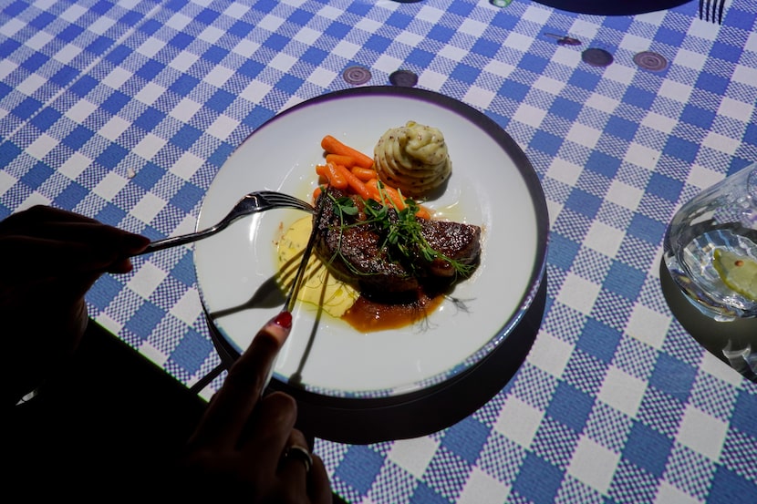 A blue and white tablecloth? Not quite: Le Petit Chef projects colors and patterns onto...