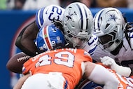 Dallas Cowboys running back Jaydon Blue (23) fumbles as he is hit by Denver Broncos...
