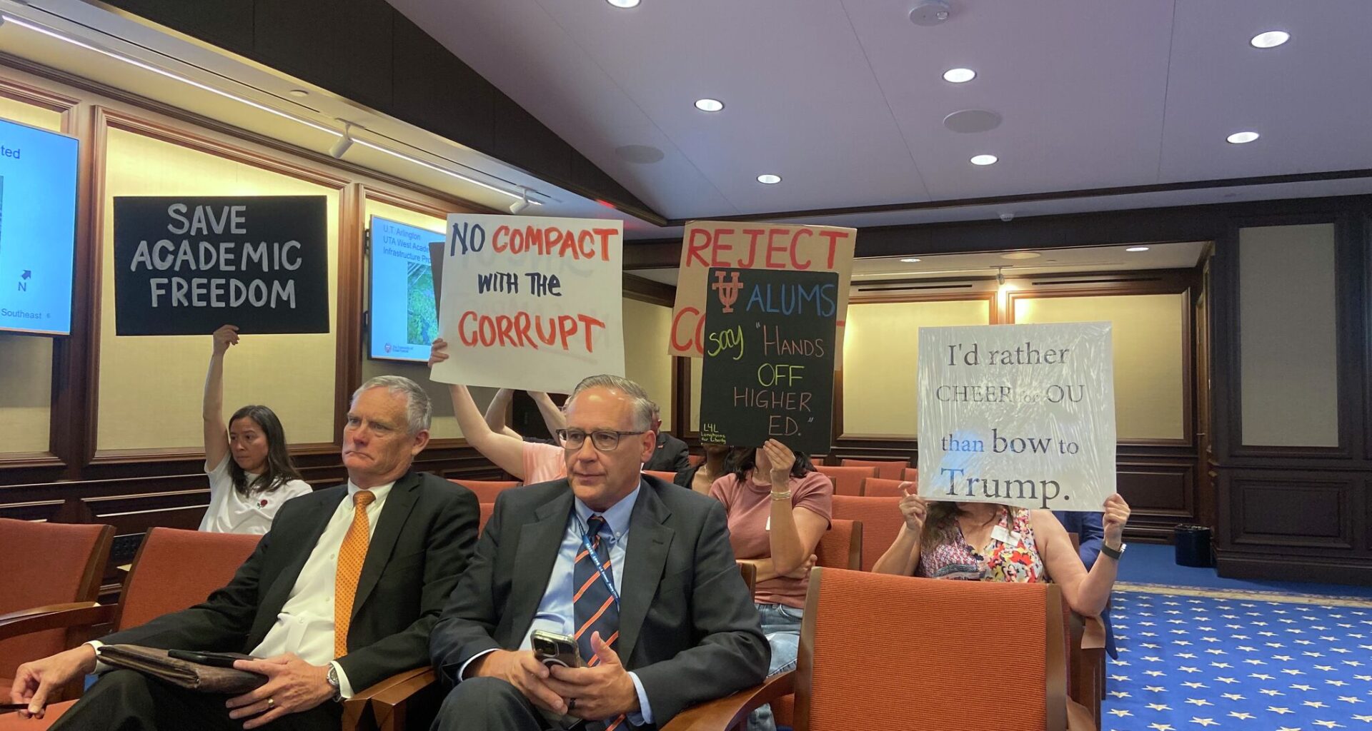 Silent protesters urge University of Texas System Board of Regents to reject the compact offer the President Donald Trump Administration sent the system's flagship school at the Nov. 19 board meeting.