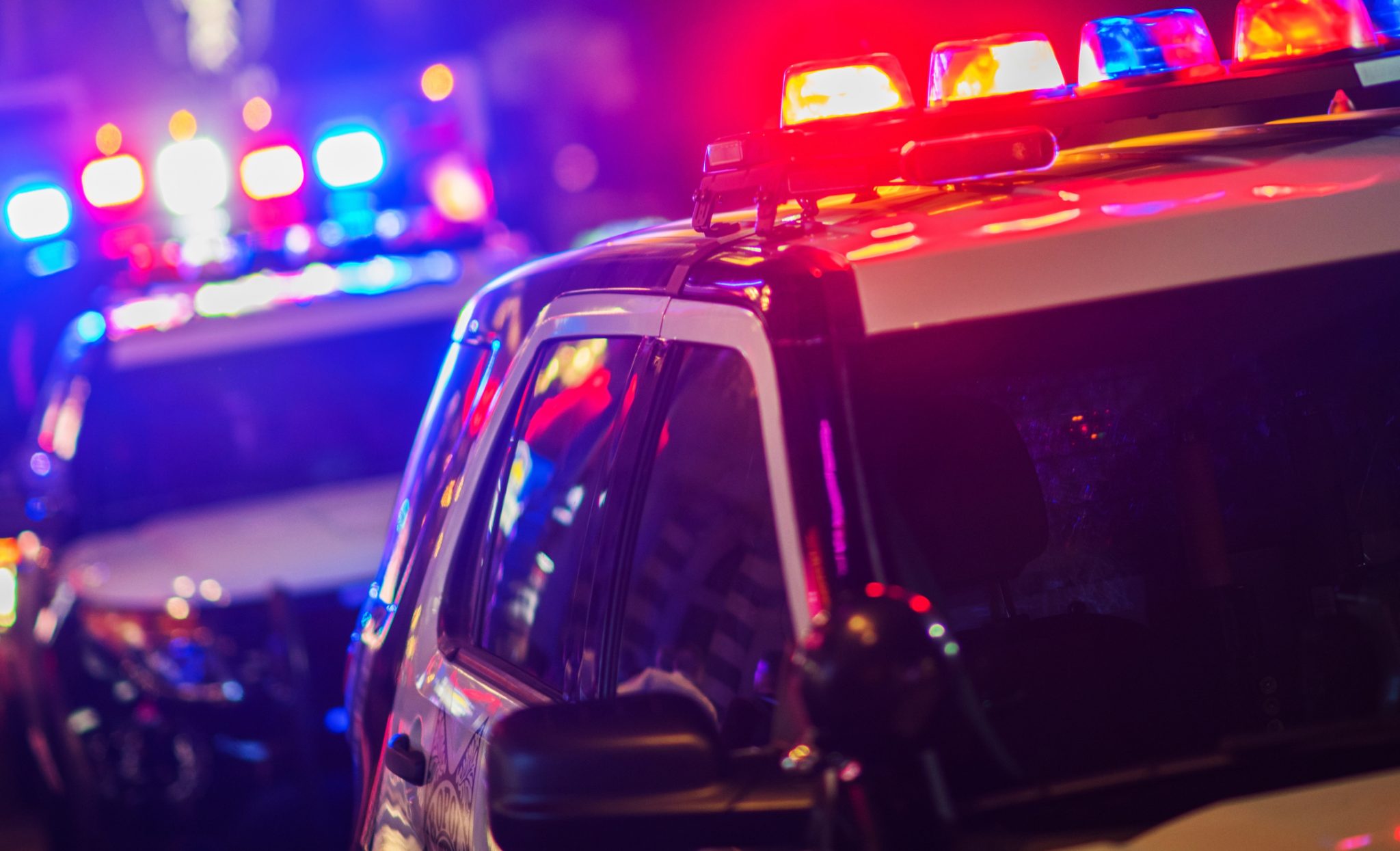 A police car with flashing lights at night.