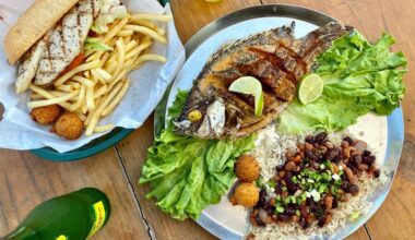 Overview of entire fish grilled on a plate and a fish sandwich.