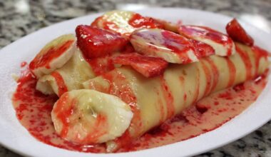 Strawberry banana crepes on a plate.