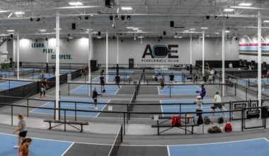 Indoor pickleball courts with Ace Pickleball Club signage on a wall.
