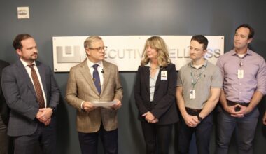 People talk standing in front of a sign