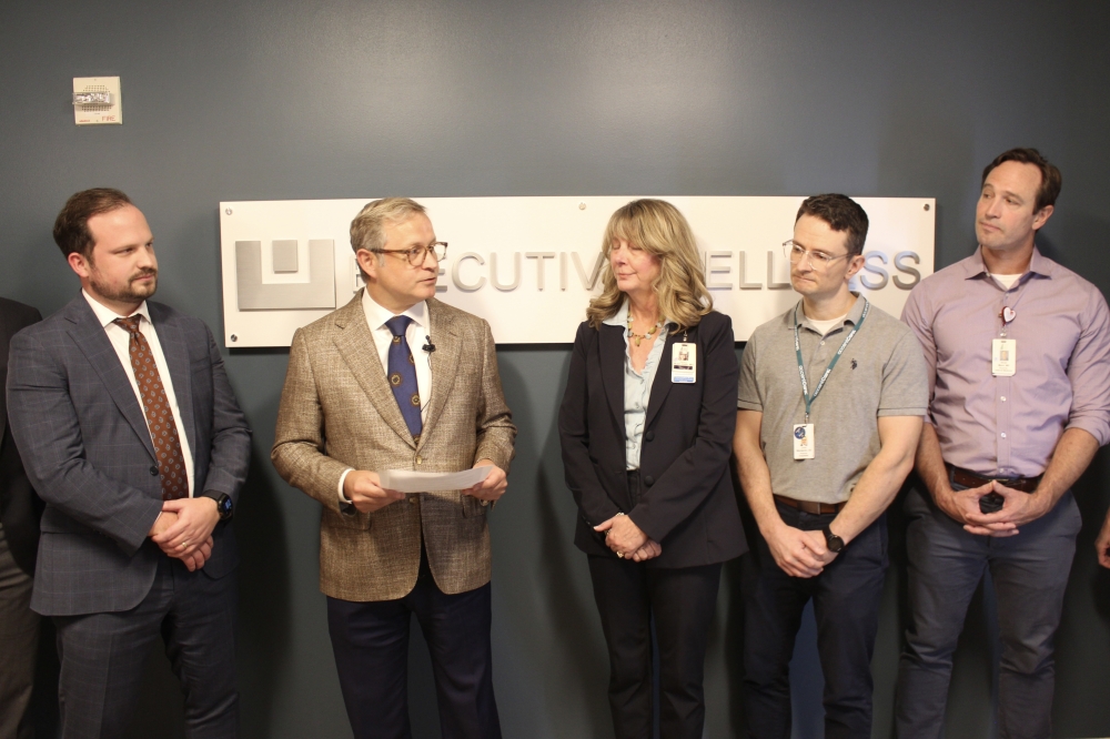 People talk standing in front of a sign