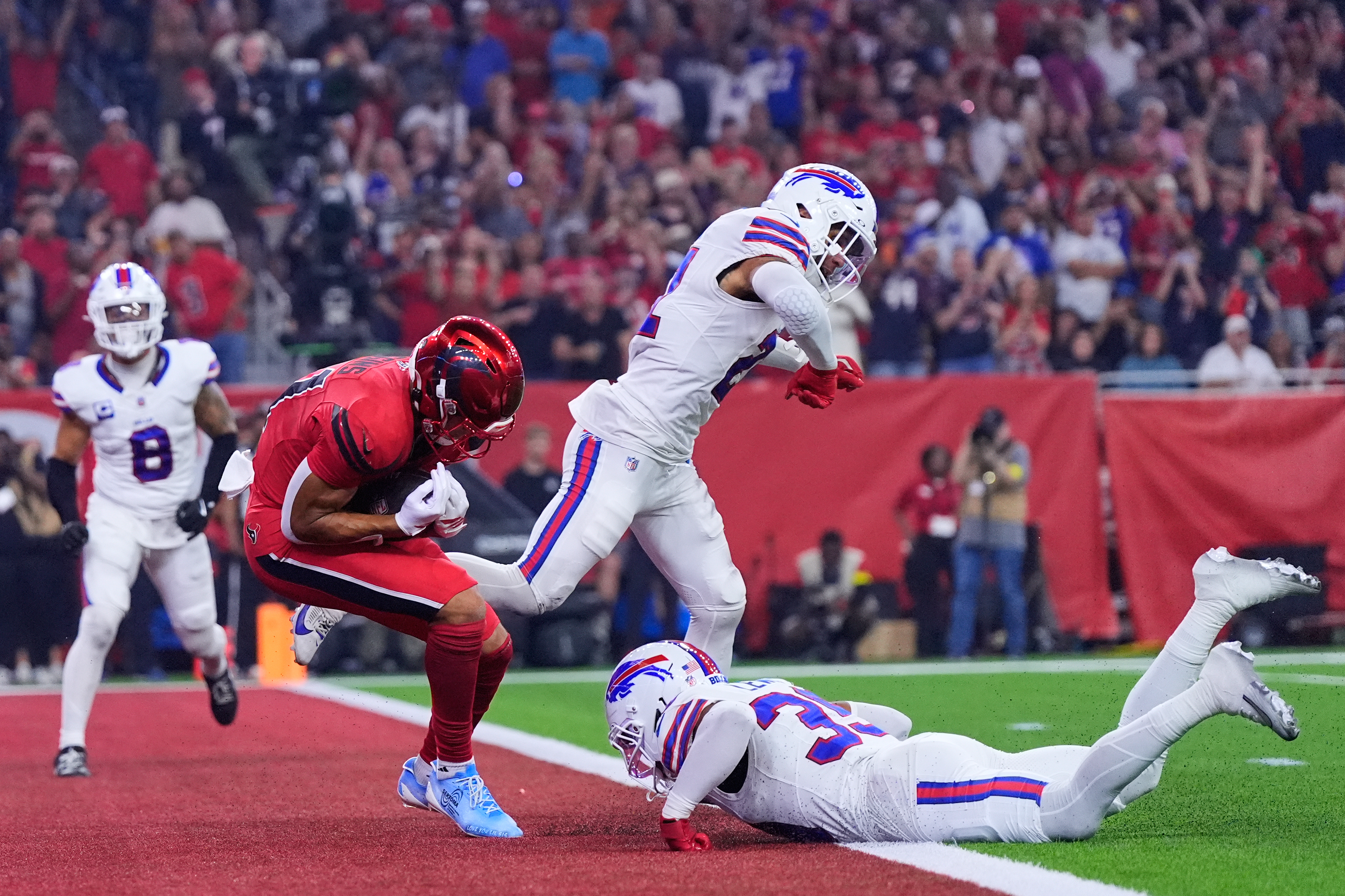 Houston Texans wide receiver Jayden Higgins, left, catches a touchdown pass in front of Buffalo Bills' Jordan Poyer, center, and Cam Lewis, bottom right, in the first half of an NFL football game Thursday, Nov. 20, 2025, in Houston. (AP Photo/Ashley Landis)