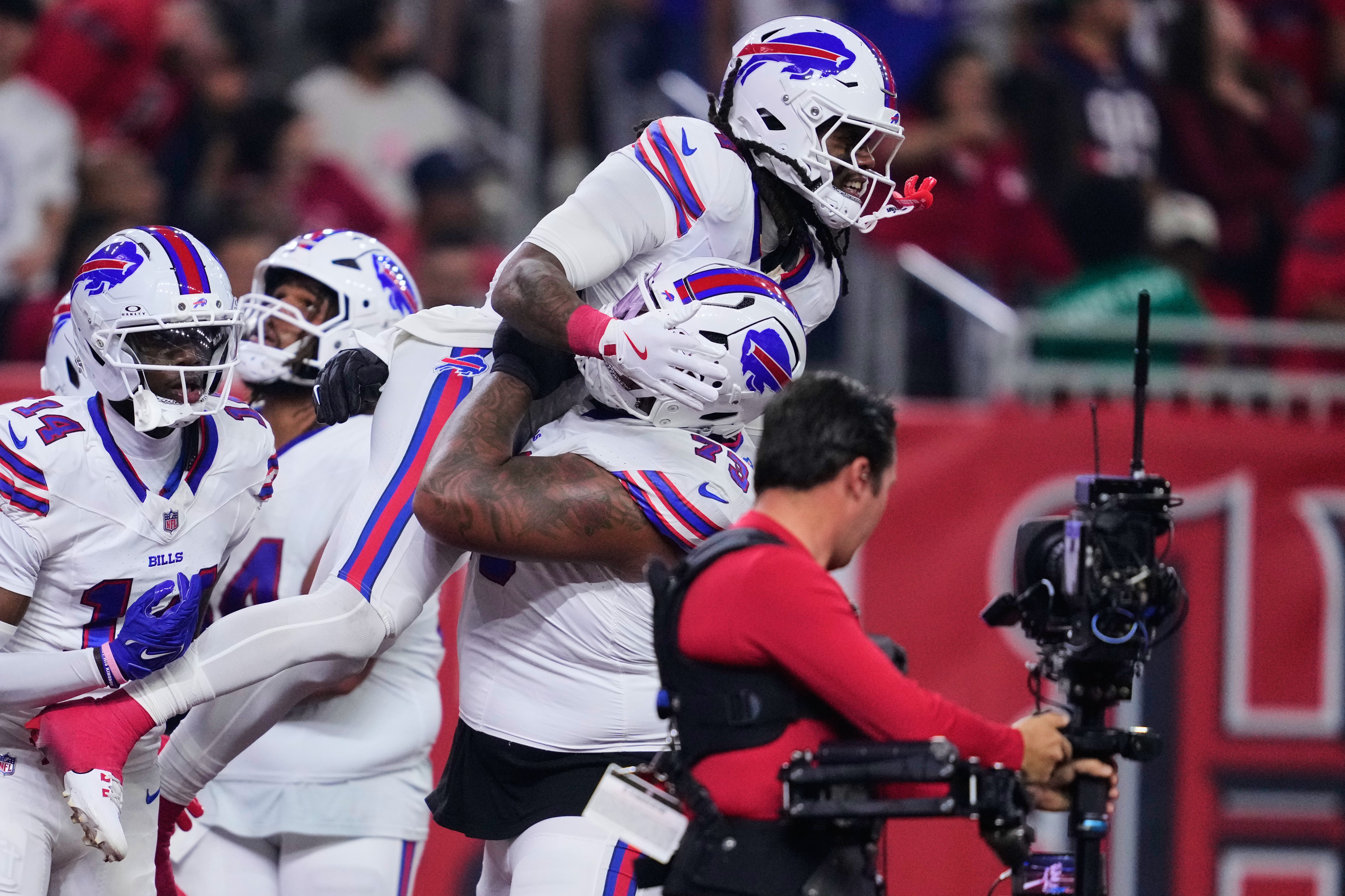 Buffalo Bills running back James Cook III, top, is lifted by Dion Dawkins (73) as the two celebrate Cook's touchdow run in the first half of an NFL football game against the Houston Texans Thursday, Nov. 20, 2025, in Houston. (AP Photo/Ashley Landis)