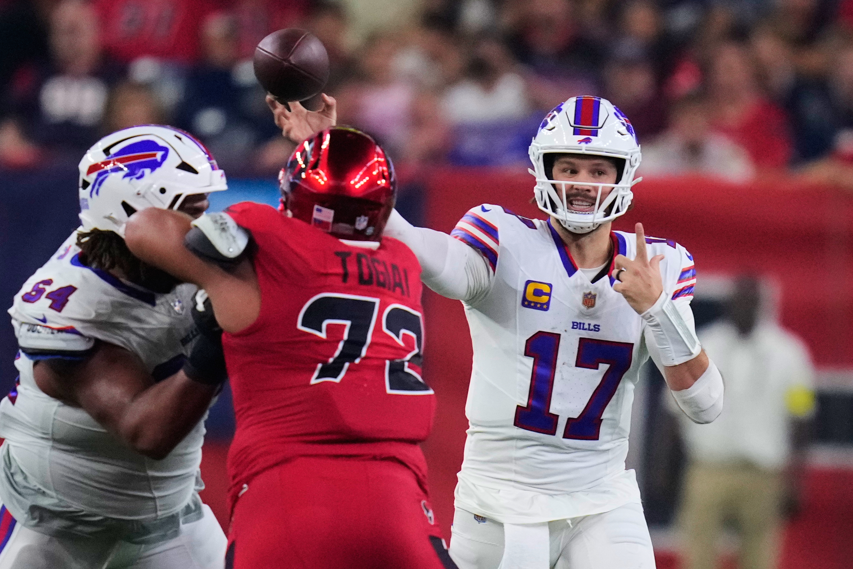 Buffalo Bills quarterback Josh Allen (17) throws a pass under pressure from Houston Texans defensive tackle Tommy Togiai (72) in the first half of an NFL football game Thursday, Nov. 20, 2025, in Houston. (AP Photo/Eric Christian Smith)