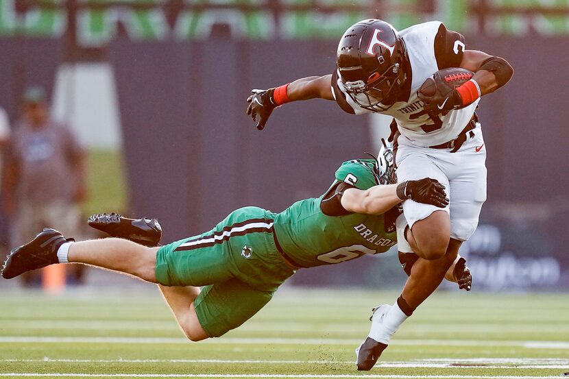Euless Trinity’s Zo Palmore (3) is brought down by Southlake Carroll defensive back Parker...