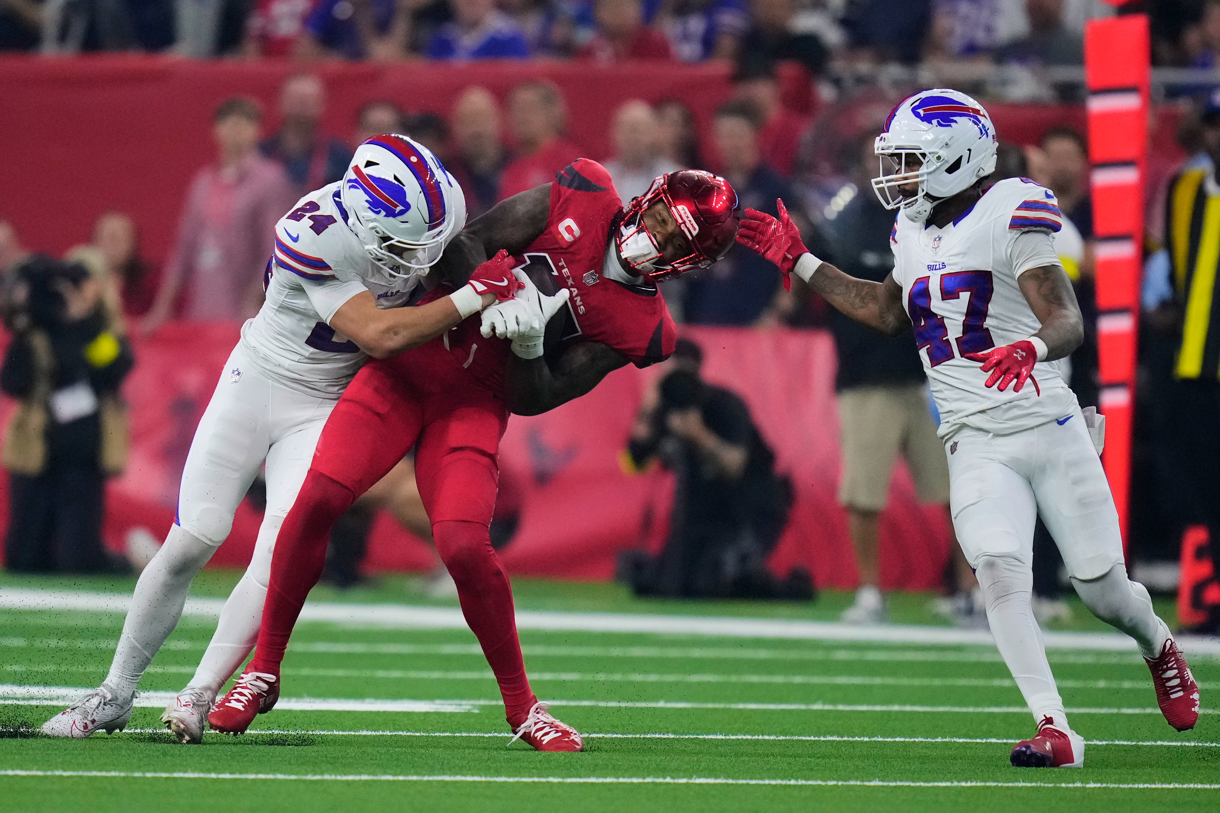 Buffalo Bills safety Cole Bishop (24) tackles Houston Texans wide receiver Nico Collins (12) after Collins caught a pass as Christian Benford (47) helps defend on the play in the first half of an NFL football game Thursday, Nov. 20, 2025, in Houston. (AP Photo/Eric Christian Smith)