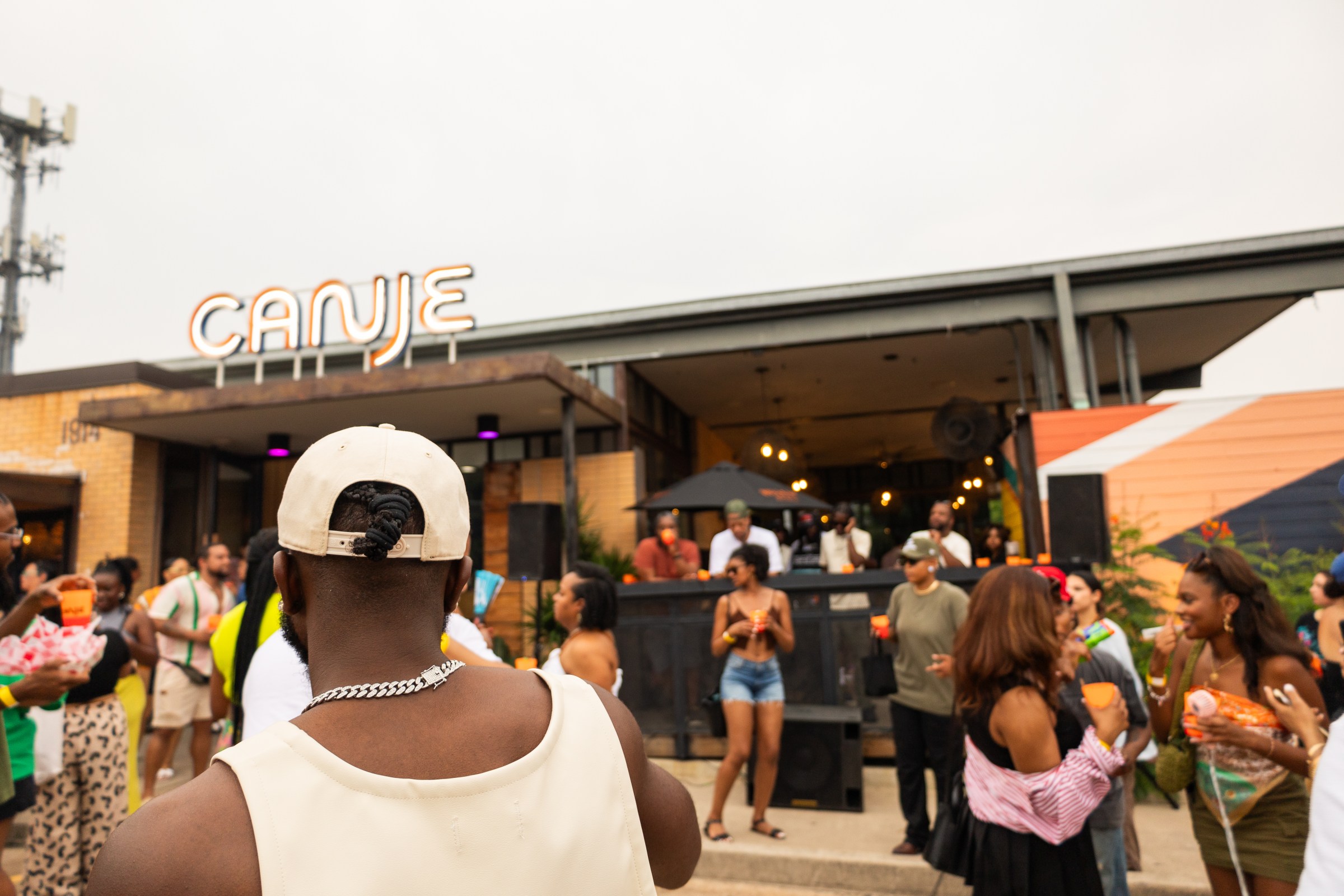 Lots of people gather outside a restaurant for a block party.