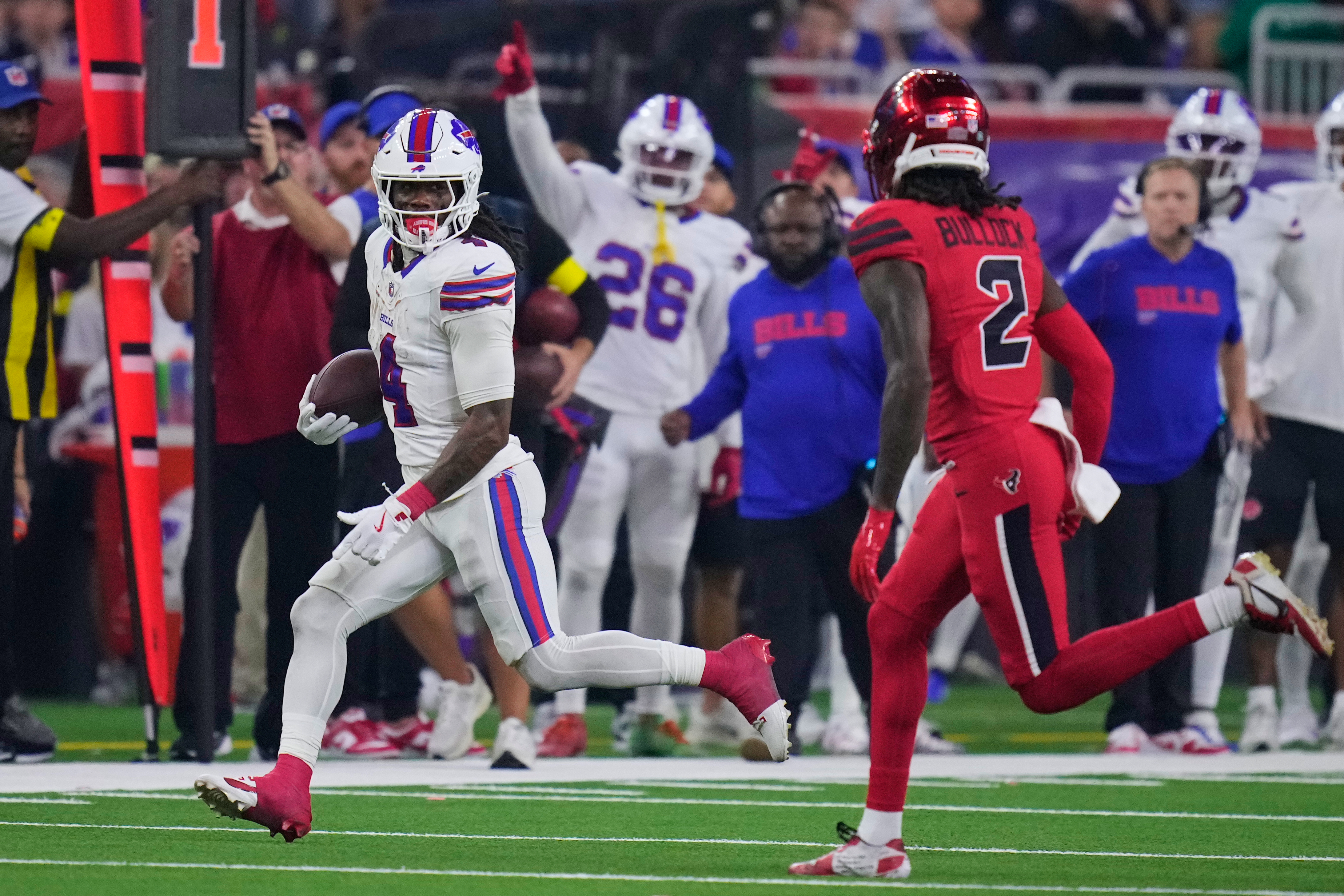 Buffalo Bills running back James Cook III (4) runs the ball as Houston Texans safety Calen Bullock (2) defends in the first half of an NFL football game Thursday, Nov. 20, 2025, in Houston. (AP Photo/Eric Christian Smith)